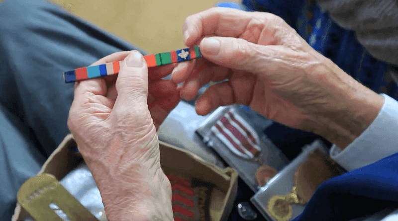 Geoffrey Casson, one of the five western Manitoba veterans interviewed for the project, is holding a military ribbon in his hands.